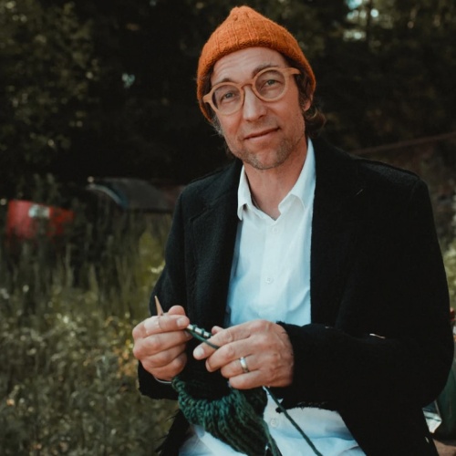 Janne Rauhansuu. Kuvassa henkilö oranssi pipo päässä metsässä.